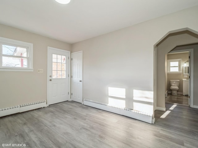 interior space featuring baseboard heating and hardwood / wood-style floors