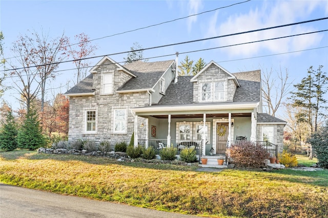 cape cod home featuring a front lawn and a porch