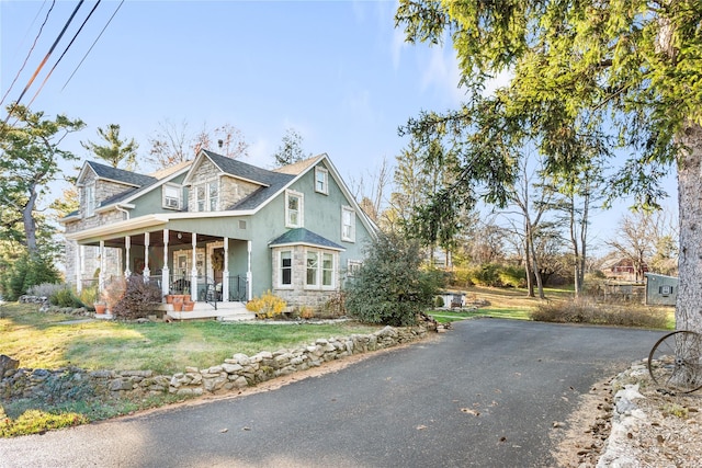 view of front of home with covered porch and a front lawn