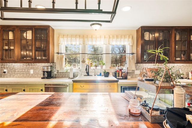 kitchen featuring decorative backsplash, stainless steel dishwasher, and sink