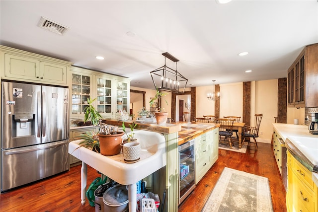 kitchen with stainless steel fridge, decorative light fixtures, beverage cooler, and dark wood-type flooring