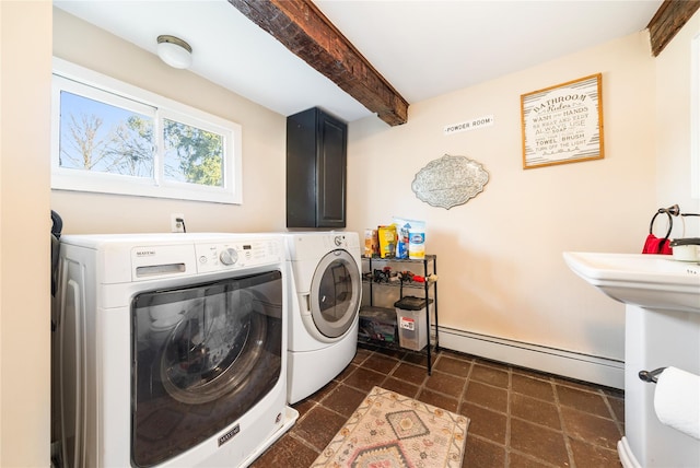 washroom with cabinets, washing machine and dryer, and a baseboard heating unit