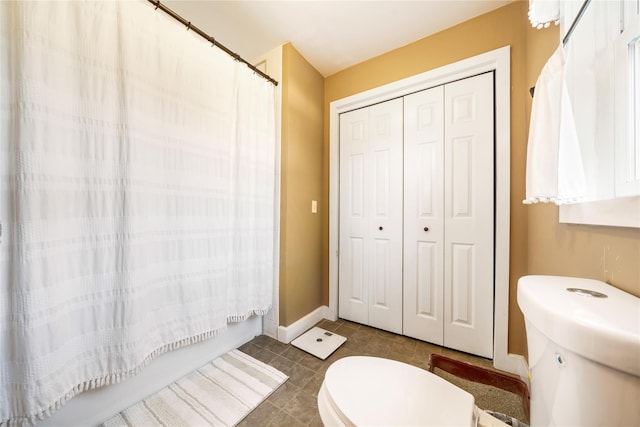 bathroom featuring tile patterned floors, shower / tub combo with curtain, and toilet