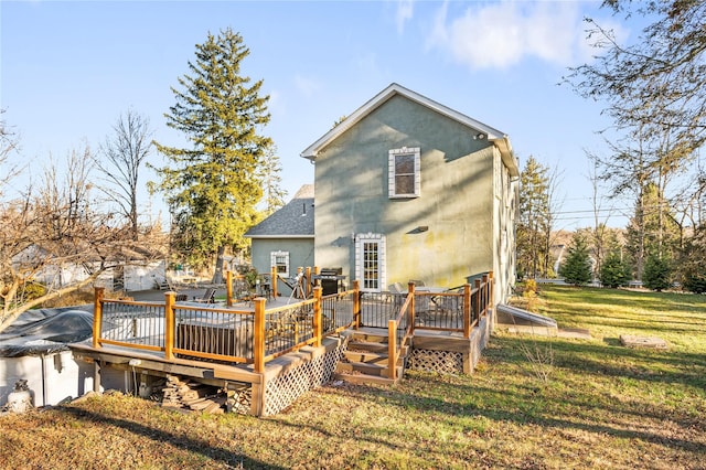 rear view of property featuring a yard and a wooden deck