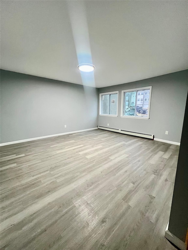 empty room with a baseboard radiator and light wood-type flooring