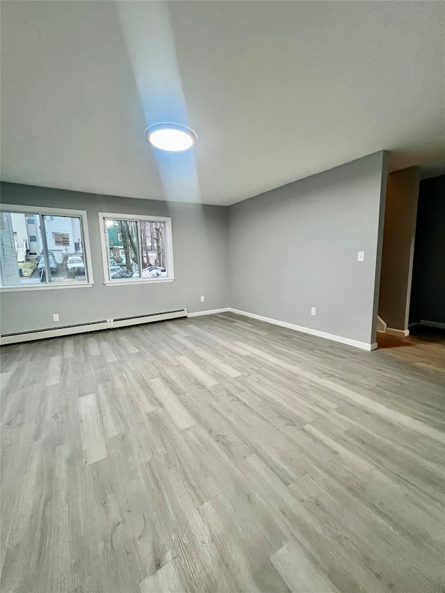 empty room featuring light hardwood / wood-style flooring and a baseboard radiator