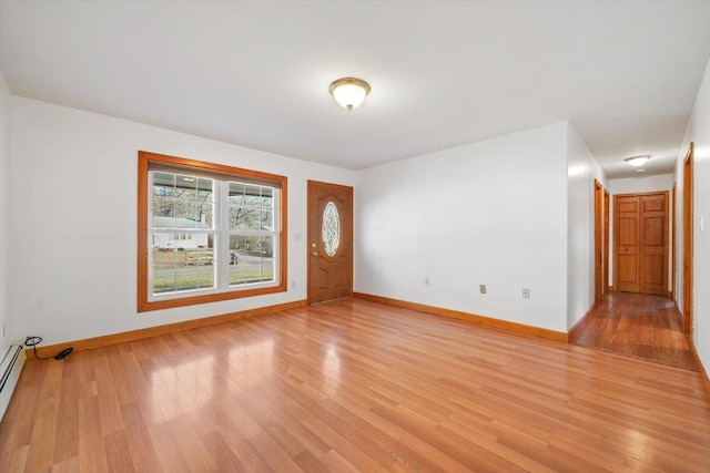 unfurnished room with light hardwood / wood-style floors and a baseboard radiator