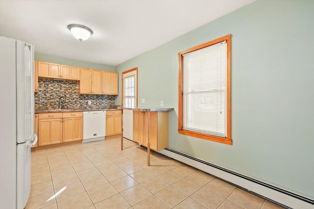 kitchen with white appliances, sink, baseboard heating, tasteful backsplash, and light tile patterned flooring