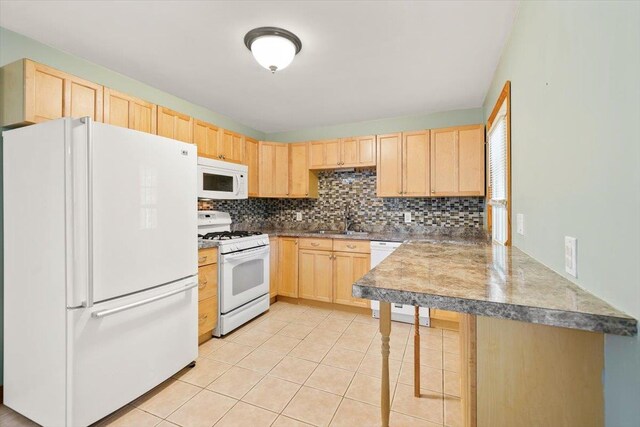 kitchen with sink, backsplash, white appliances, light brown cabinetry, and light tile patterned flooring