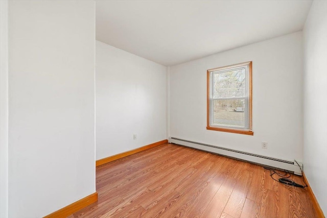 empty room with a baseboard radiator and light wood-type flooring