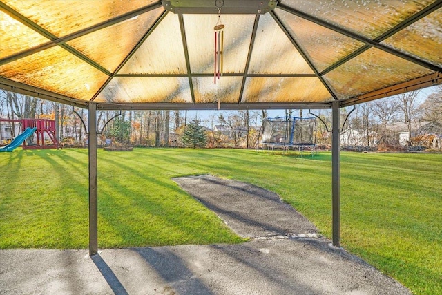 view of yard with a playground and a trampoline