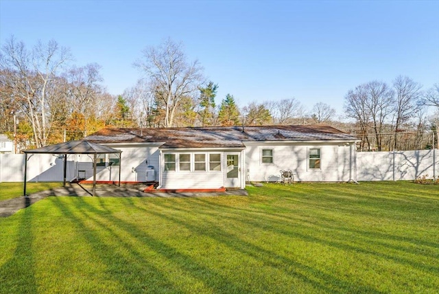 back of property with a gazebo and a yard