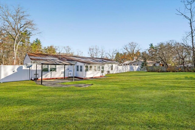 rear view of house with a gazebo and a lawn