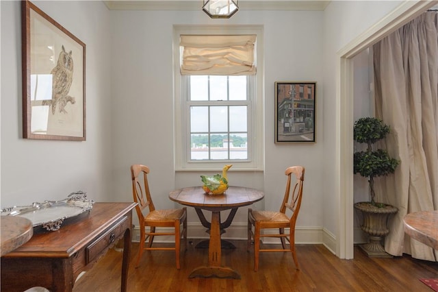 dining space featuring dark hardwood / wood-style flooring, breakfast area, and ornamental molding