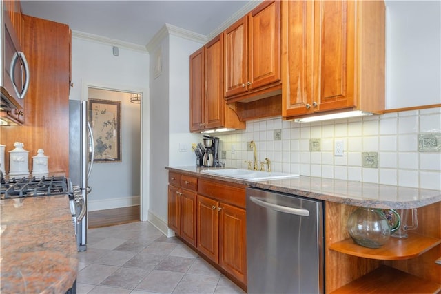 kitchen featuring light stone counters, sink, ornamental molding, and appliances with stainless steel finishes