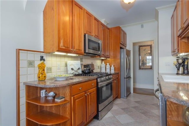 kitchen featuring appliances with stainless steel finishes, tasteful backsplash, ornamental molding, dark stone counters, and light tile patterned floors