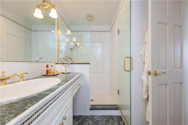 bathroom with walk in shower, vanity, and tile walls