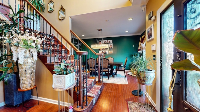 interior space with recessed lighting, wood finished floors, baseboards, ornamental molding, and stairway