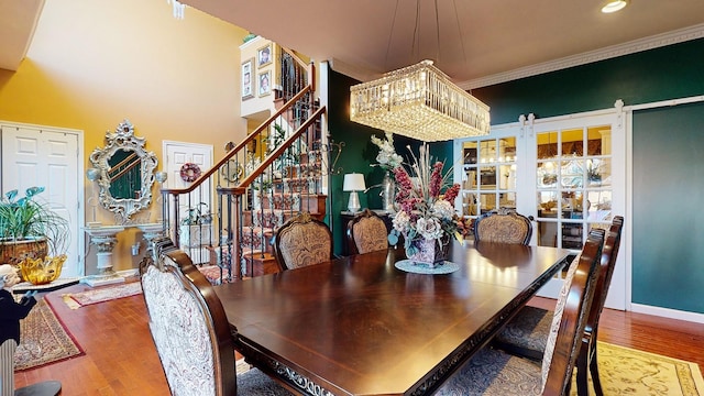 dining space with stairs, ornamental molding, wood finished floors, and baseboards