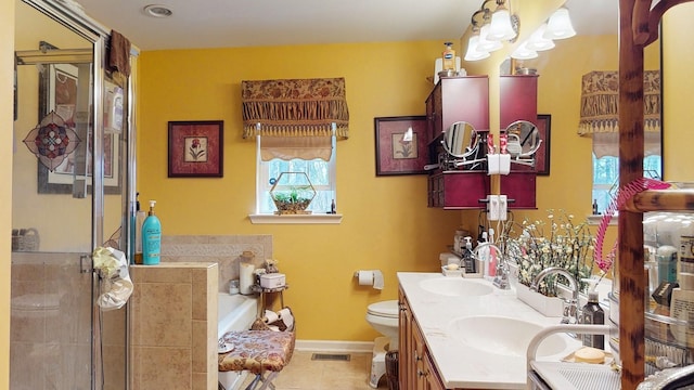 bathroom with a garden tub, a shower stall, visible vents, and a sink