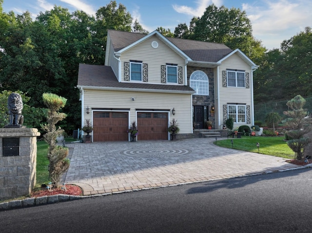 view of front facade featuring a garage, decorative driveway, and a front yard