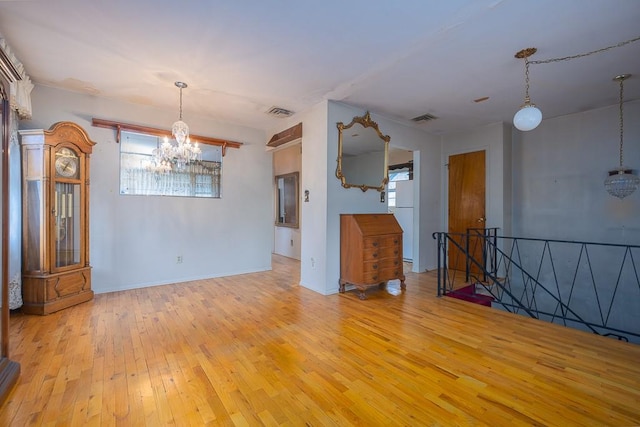 spare room featuring light hardwood / wood-style floors and a chandelier