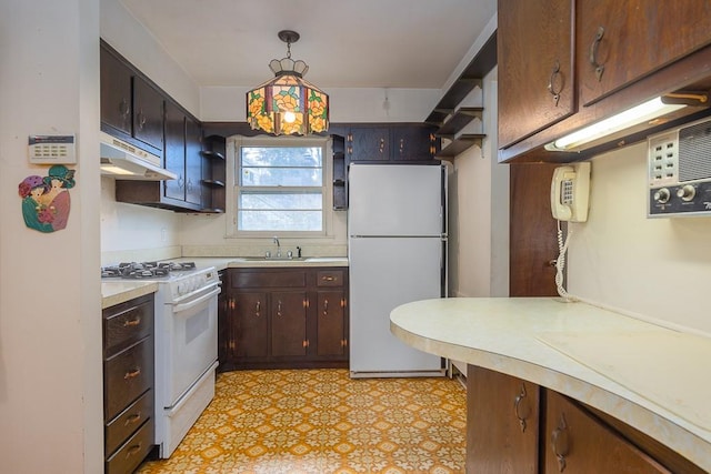 kitchen with dark brown cabinets, sink, pendant lighting, and white appliances