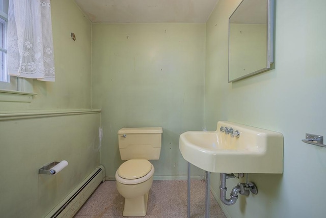 bathroom featuring baseboard heating, sink, and toilet