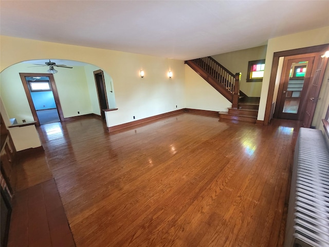 unfurnished living room featuring plenty of natural light and dark wood-type flooring