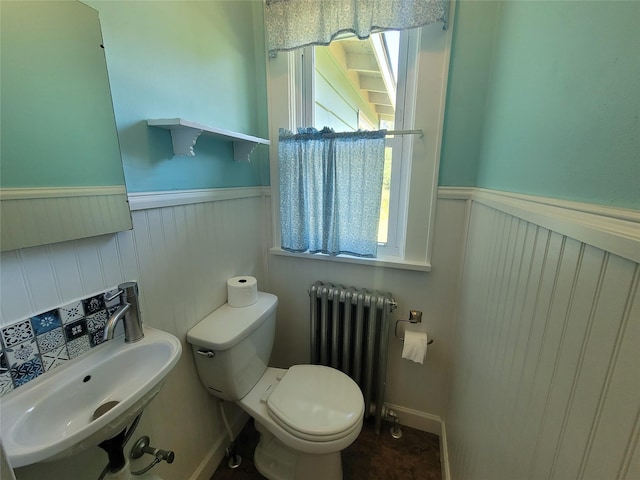 bathroom with radiator heating unit, toilet, and sink