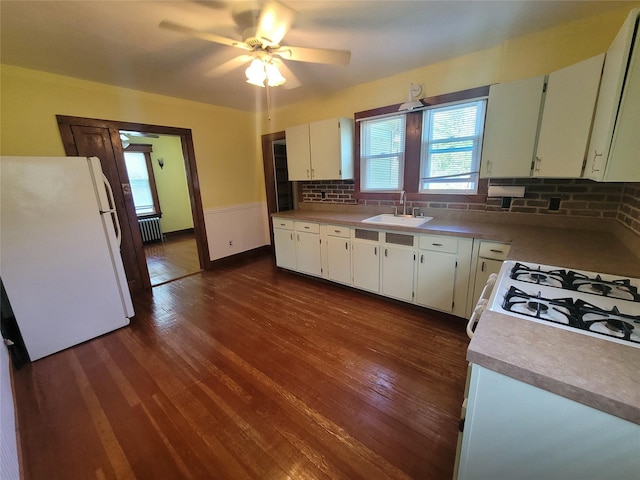 kitchen with dark hardwood / wood-style flooring, tasteful backsplash, white appliances, sink, and white cabinets