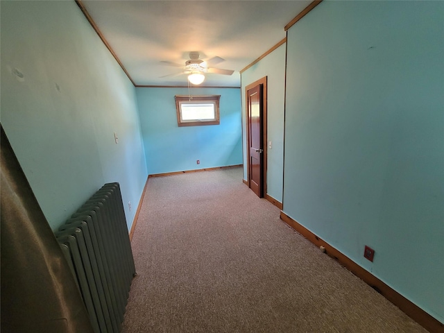 empty room with radiator, light carpet, ceiling fan, and ornamental molding