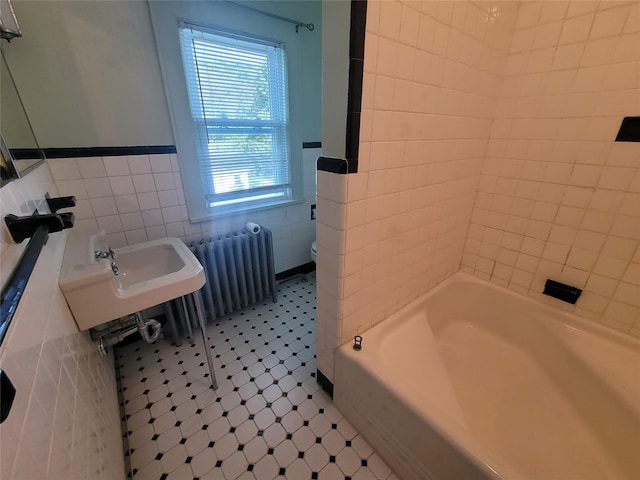 bathroom featuring tile patterned floors, toilet, tile walls, and radiator