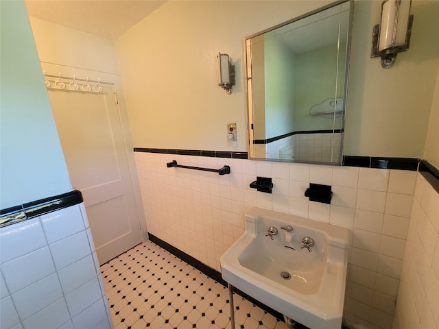 bathroom featuring sink and tile walls