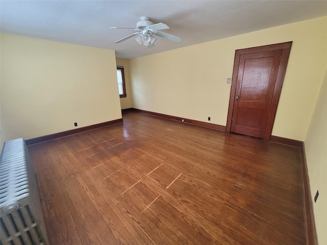 empty room with ceiling fan and dark wood-type flooring