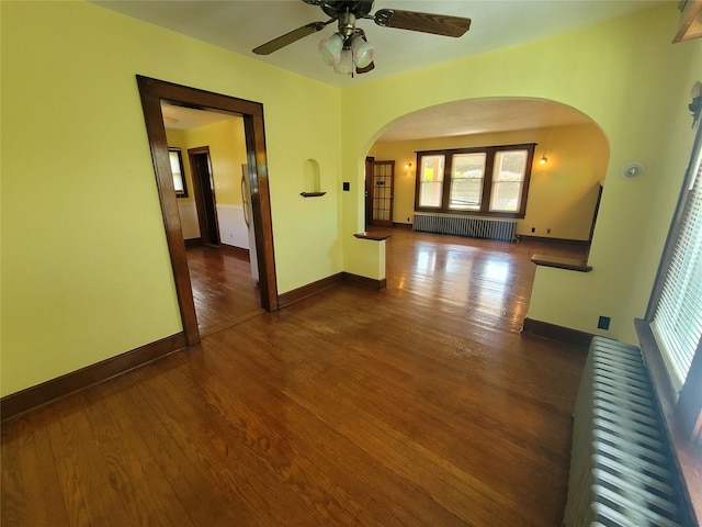 unfurnished room with radiator heating unit, dark hardwood / wood-style flooring, and ceiling fan