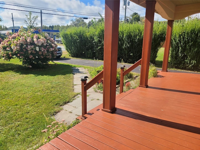 wooden terrace featuring a yard