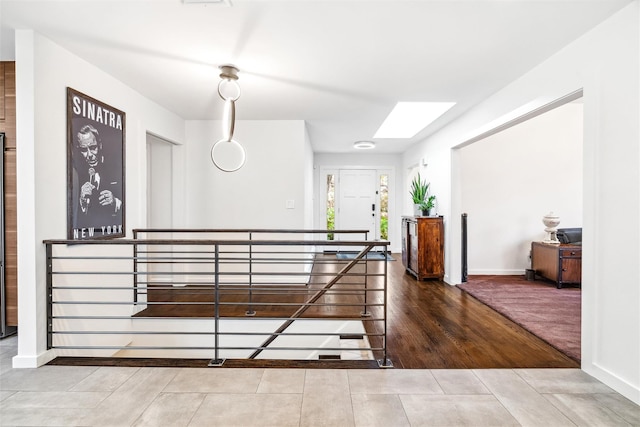 corridor featuring a skylight and wood-type flooring