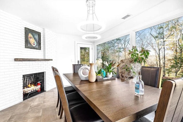 dining space with a fireplace and brick wall