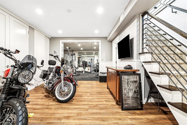 exercise area featuring light hardwood / wood-style flooring and beverage cooler