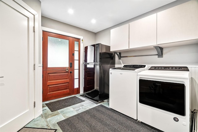 laundry room with washer and dryer and cabinets