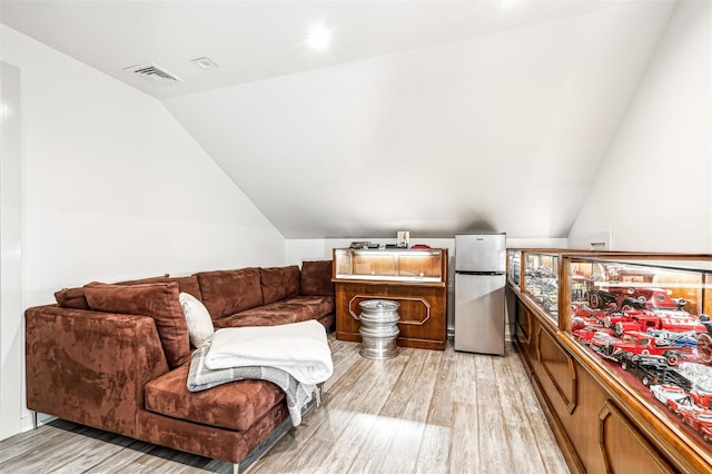 living room featuring light hardwood / wood-style flooring and vaulted ceiling