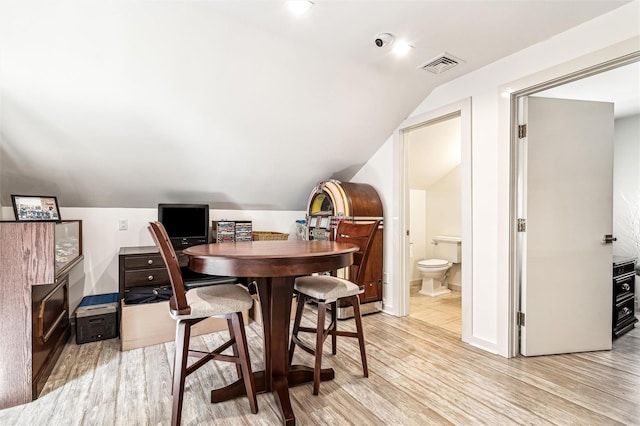 dining space featuring lofted ceiling and light wood-type flooring