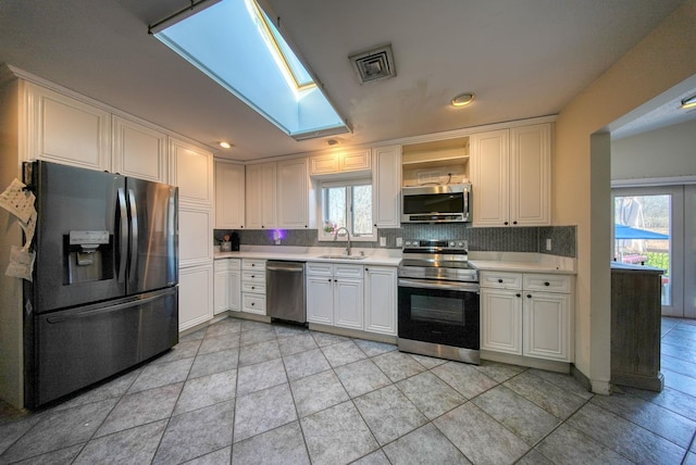 kitchen with a healthy amount of sunlight, sink, white cabinets, and stainless steel appliances