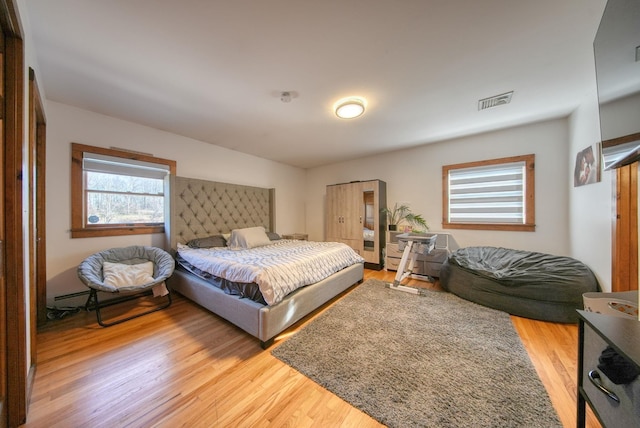 bedroom featuring light hardwood / wood-style floors and baseboard heating