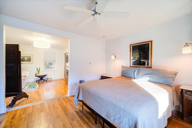 41 White Oaks Rd, Hyde Park, NY 12538 - bedroom with stacked washer / dryer, light wood-style floors, baseboards, and ceiling fan