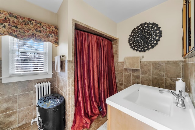 bathroom with vanity, radiator, and tile walls