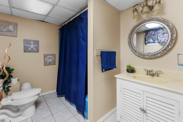 bathroom featuring tile patterned flooring, vanity, toilet, a drop ceiling, and a shower with curtain