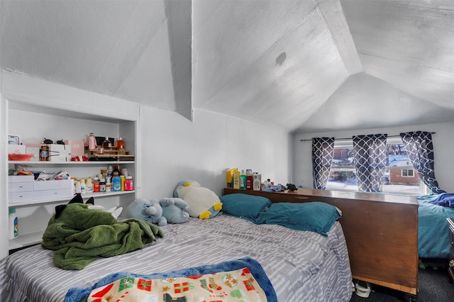 bedroom with vaulted ceiling and a textured ceiling