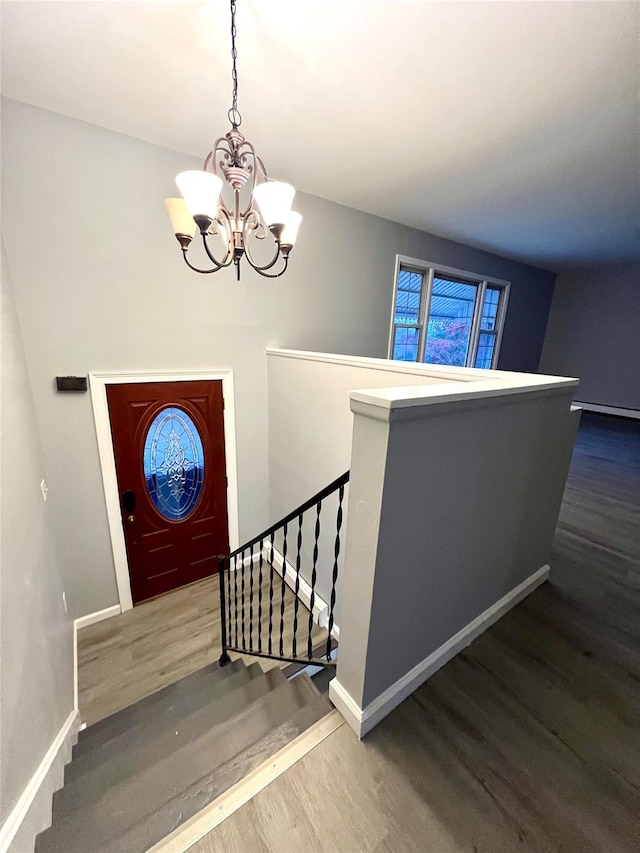 entrance foyer with wood-type flooring and a notable chandelier